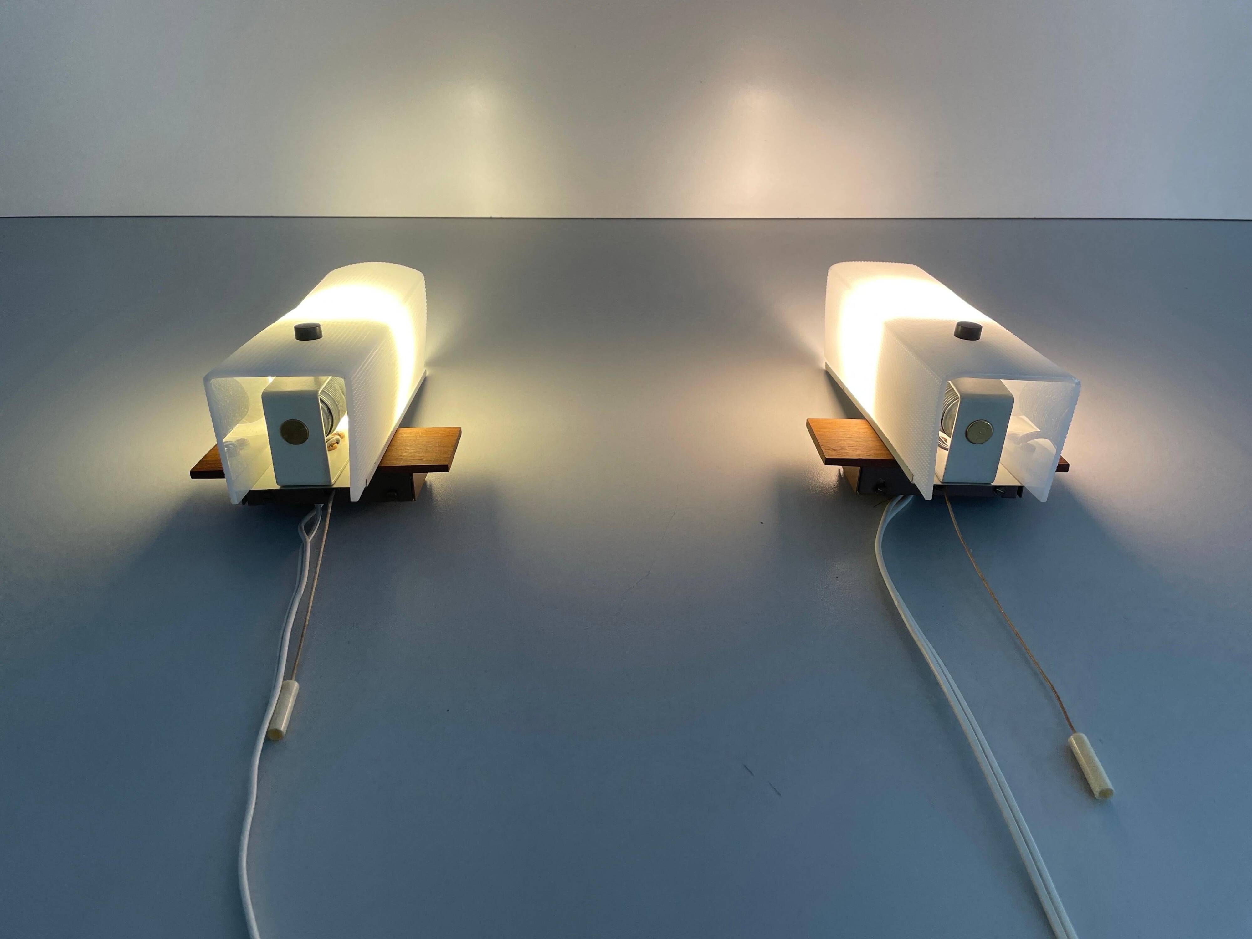 Mid-century wall lights in white plexiglass with a wooden base, 1960s, Germany.