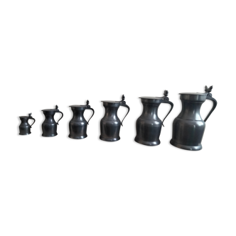 Series of 7 étain du Manoir pitchers