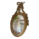 Oval convex witch mirror with golden ribbon mouldings.