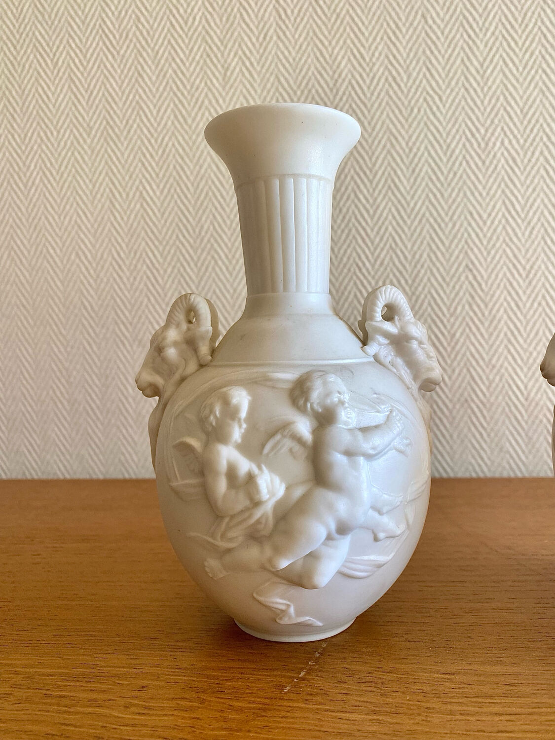 Paire de vases en biscuit decor putti et tête de bélier