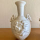 Pair of biscuit vases decorated with putti and ram's head.
