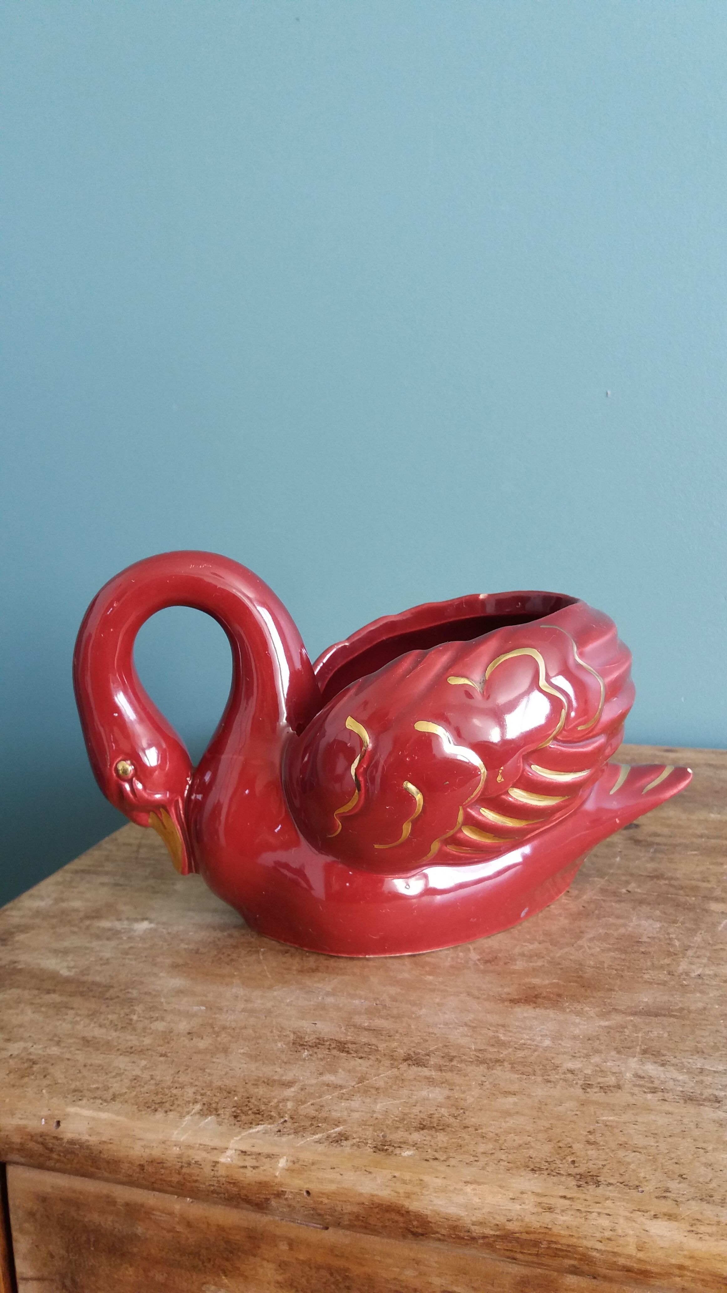 Poet Laval swan hides zoomorphic pot in burgundy ceramic.