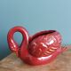 Poet Laval swan hides zoomorphic pot in burgundy ceramic.