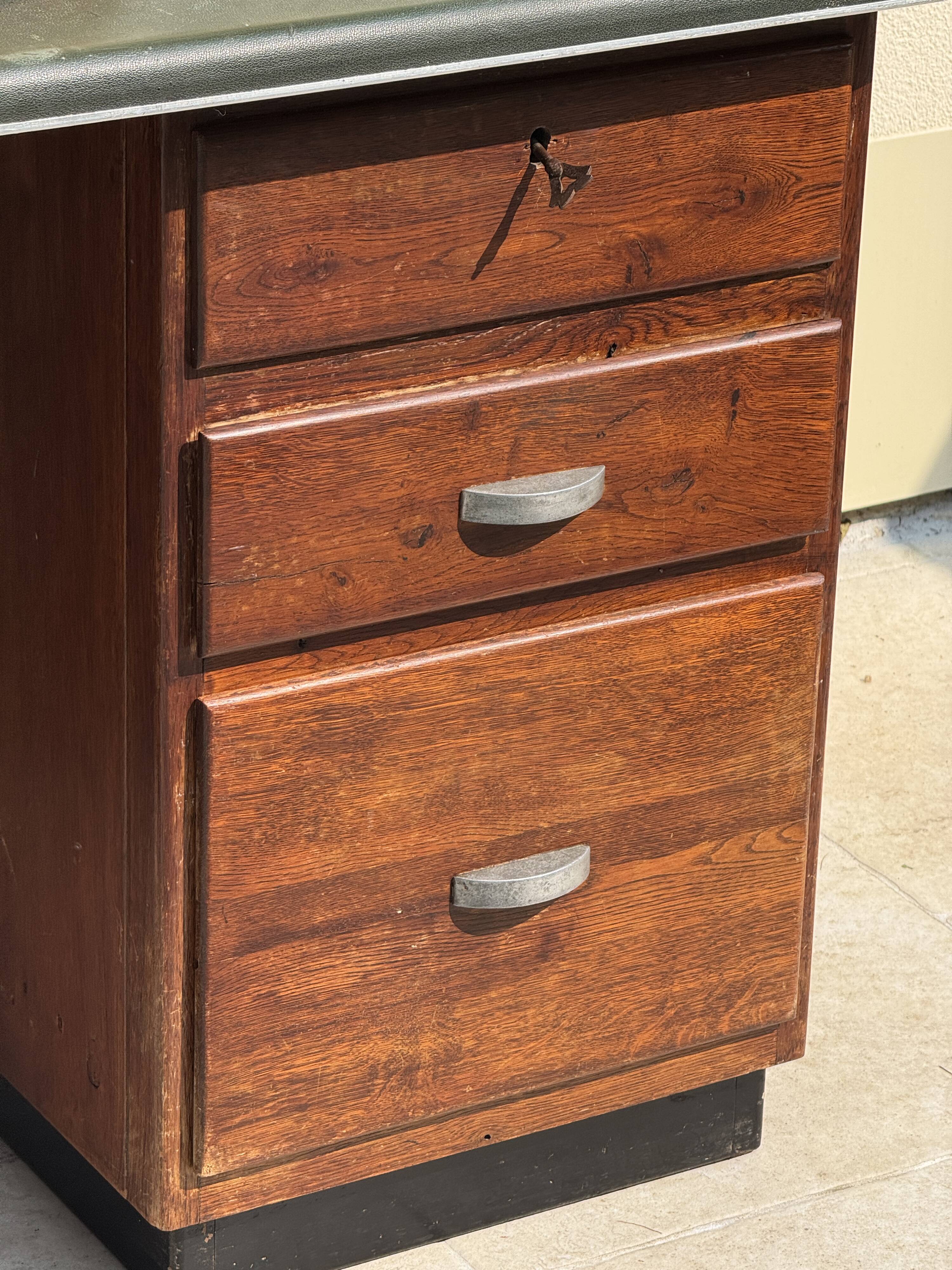 Modernist desk in wood and green moleskin upholstery