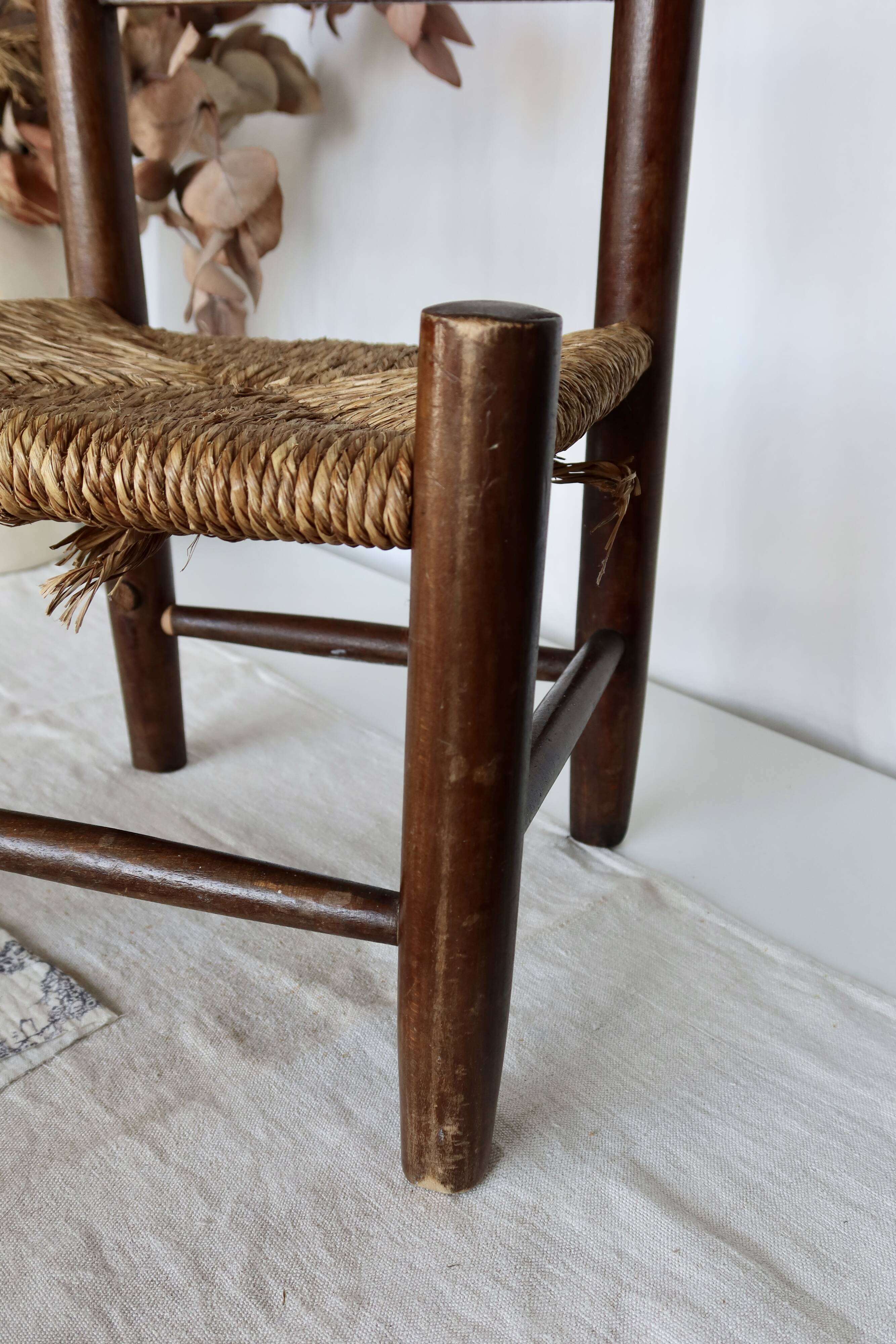 Vintage children's chair in dark wood with woven straw seat