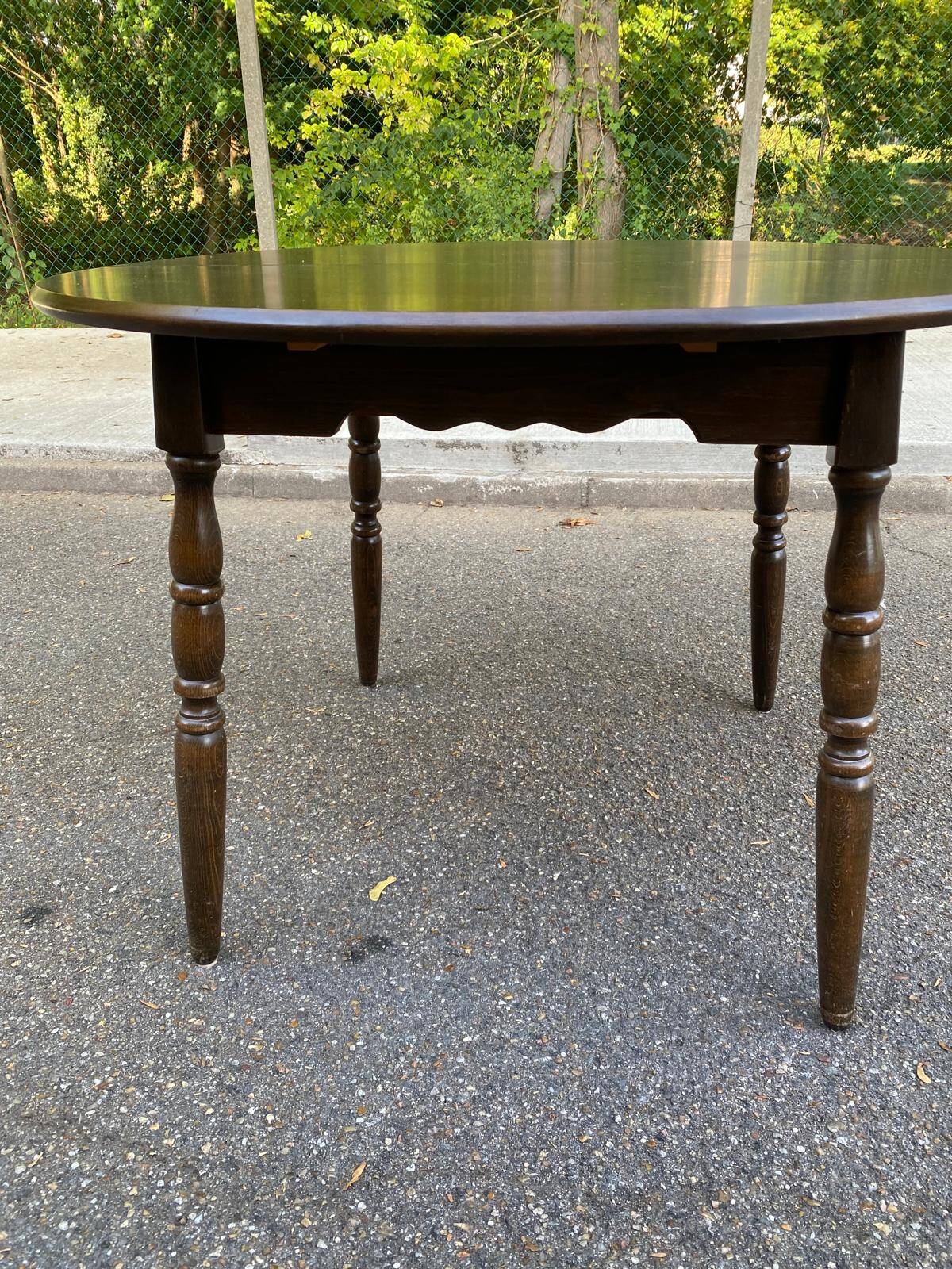 Extendable round table in solid wood with a dark oak satin finish.