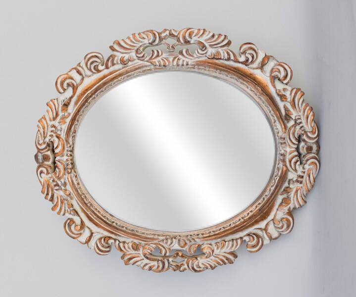 Distressed and carved golden oval mirror in wood.
