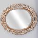 Distressed and carved golden oval mirror in wood.
