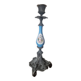 Antique candlestick made of cast metal and painted porcelain.