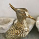 Crested bird in golden brass