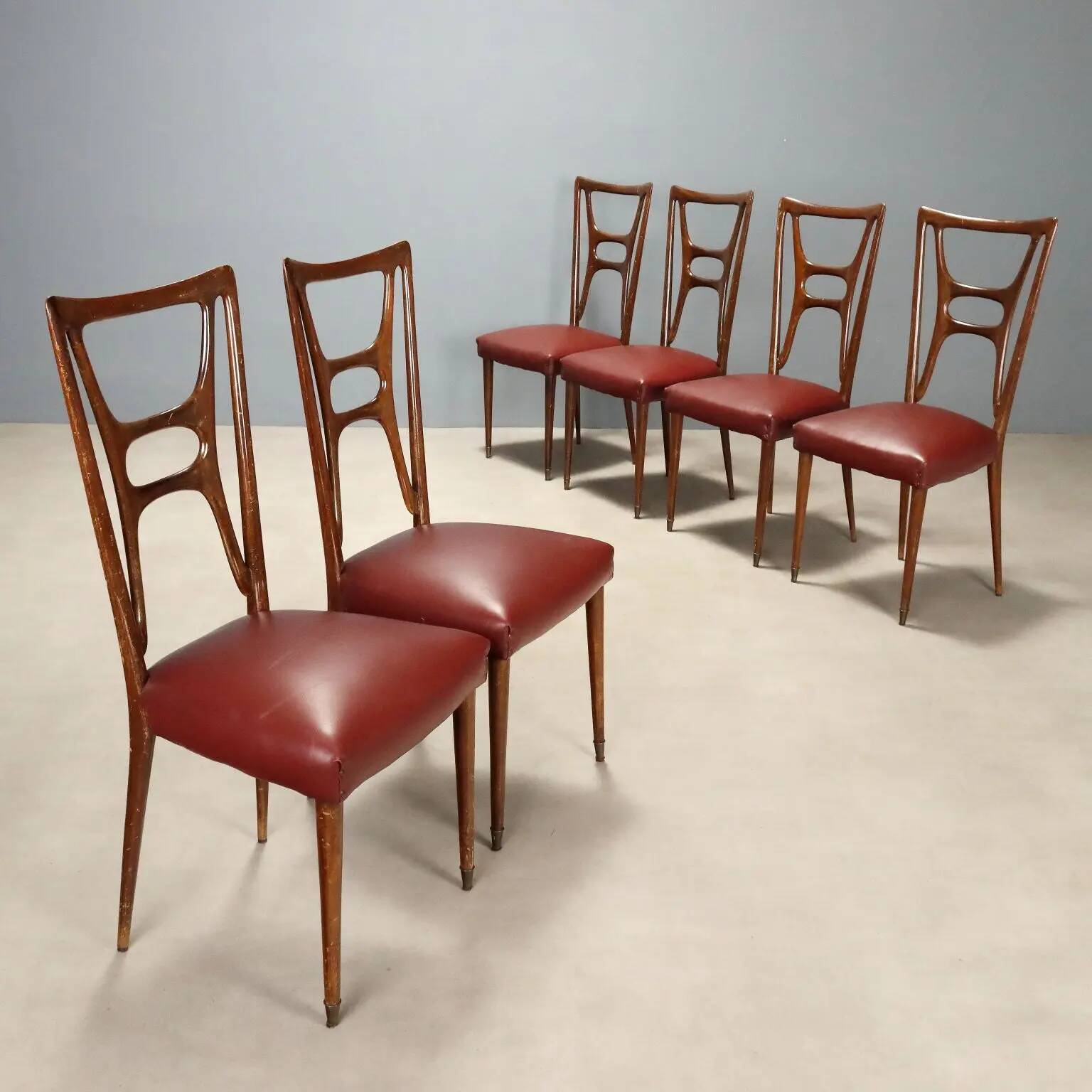 Set of six 1950s chairs with burgundy seats.