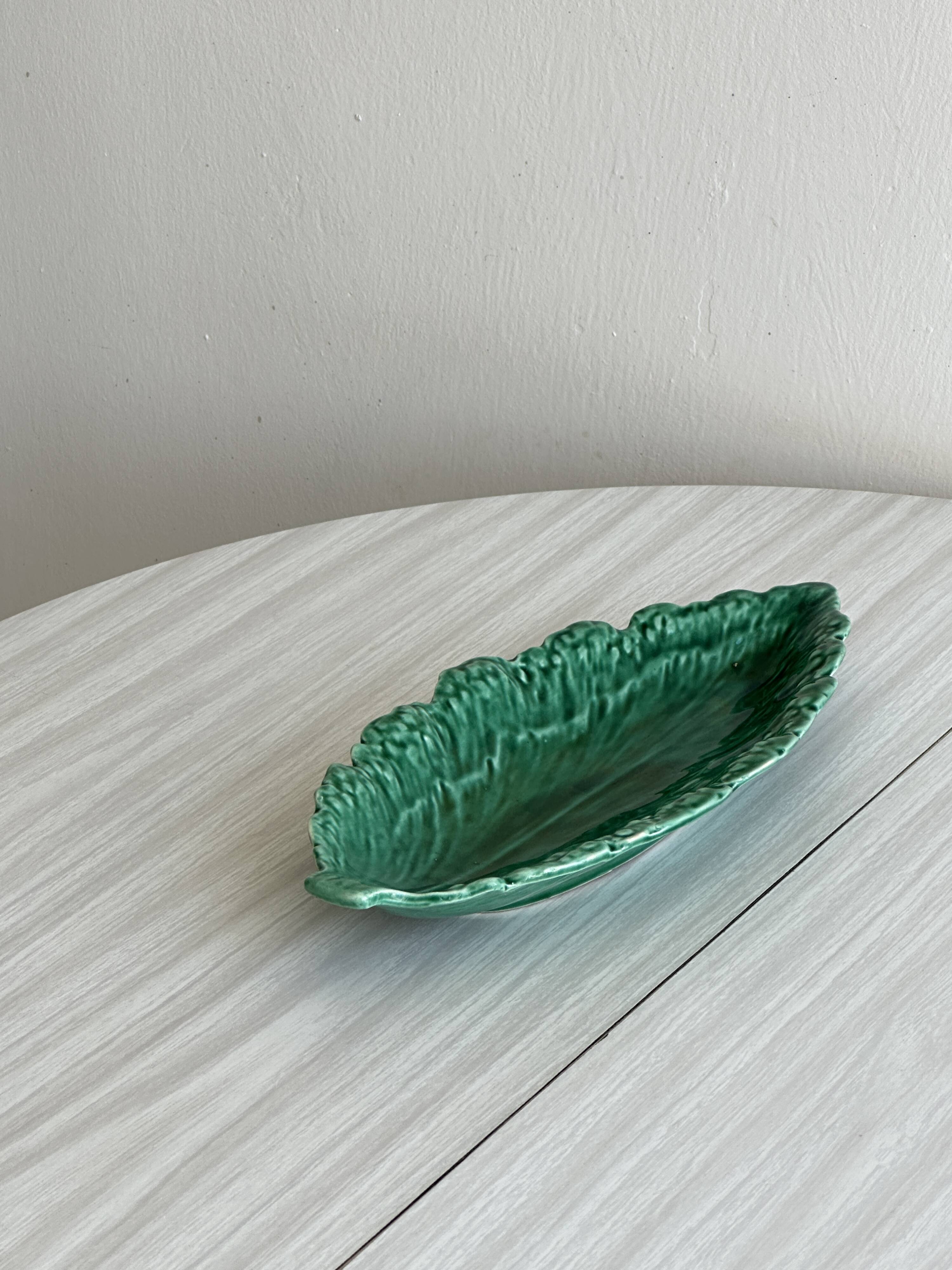 Green earthenware dish in the shape of a leaf