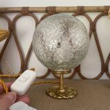 Small handcrafted globe lamp with a cracked finish and a golden brass base.