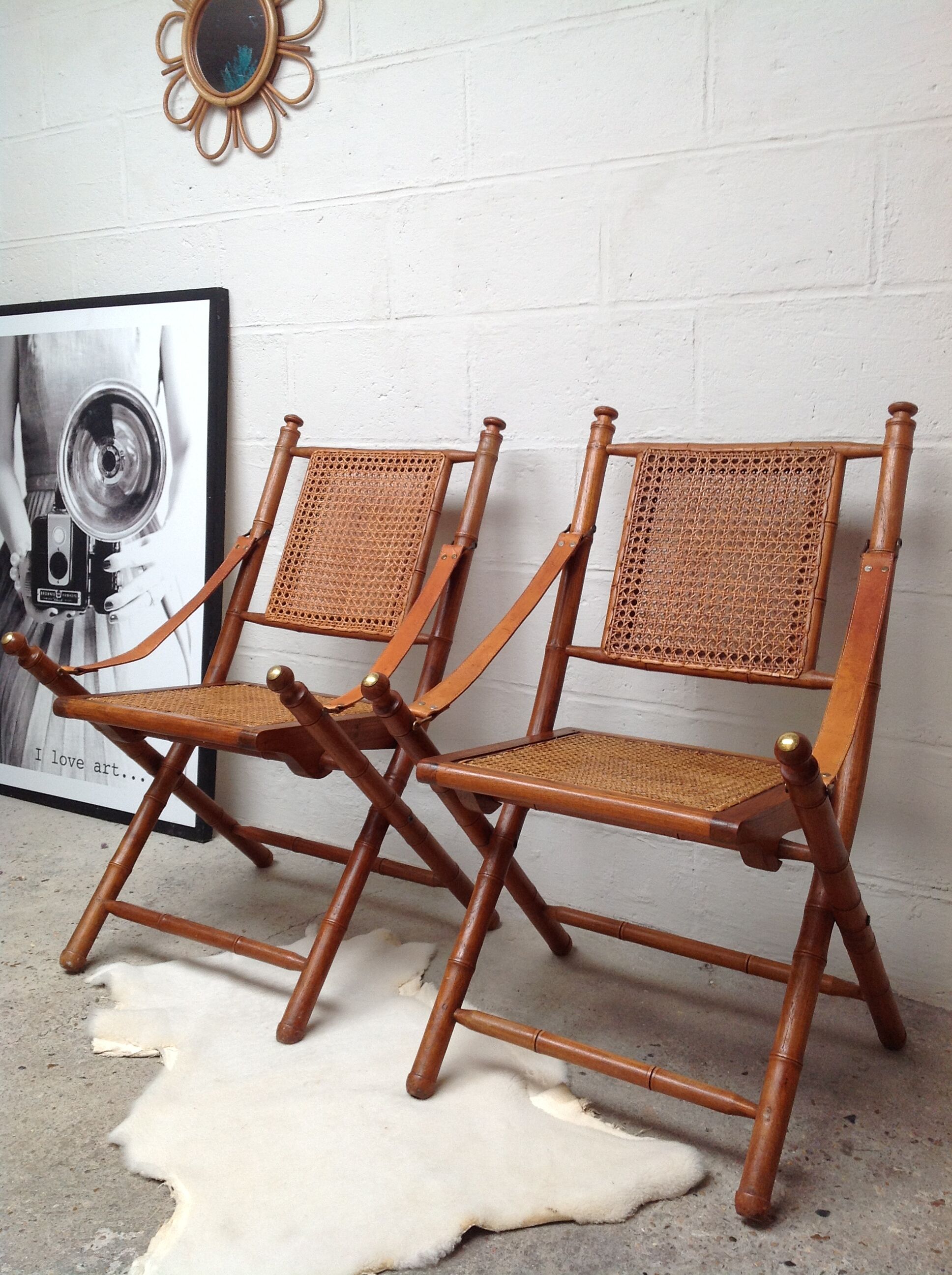Pair of folding chairs in bamboo and caning, leather and brass