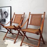 Pair of folding chairs in bamboo and caning, leather and brass