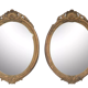 Pair of oval wooden windows with golden patina