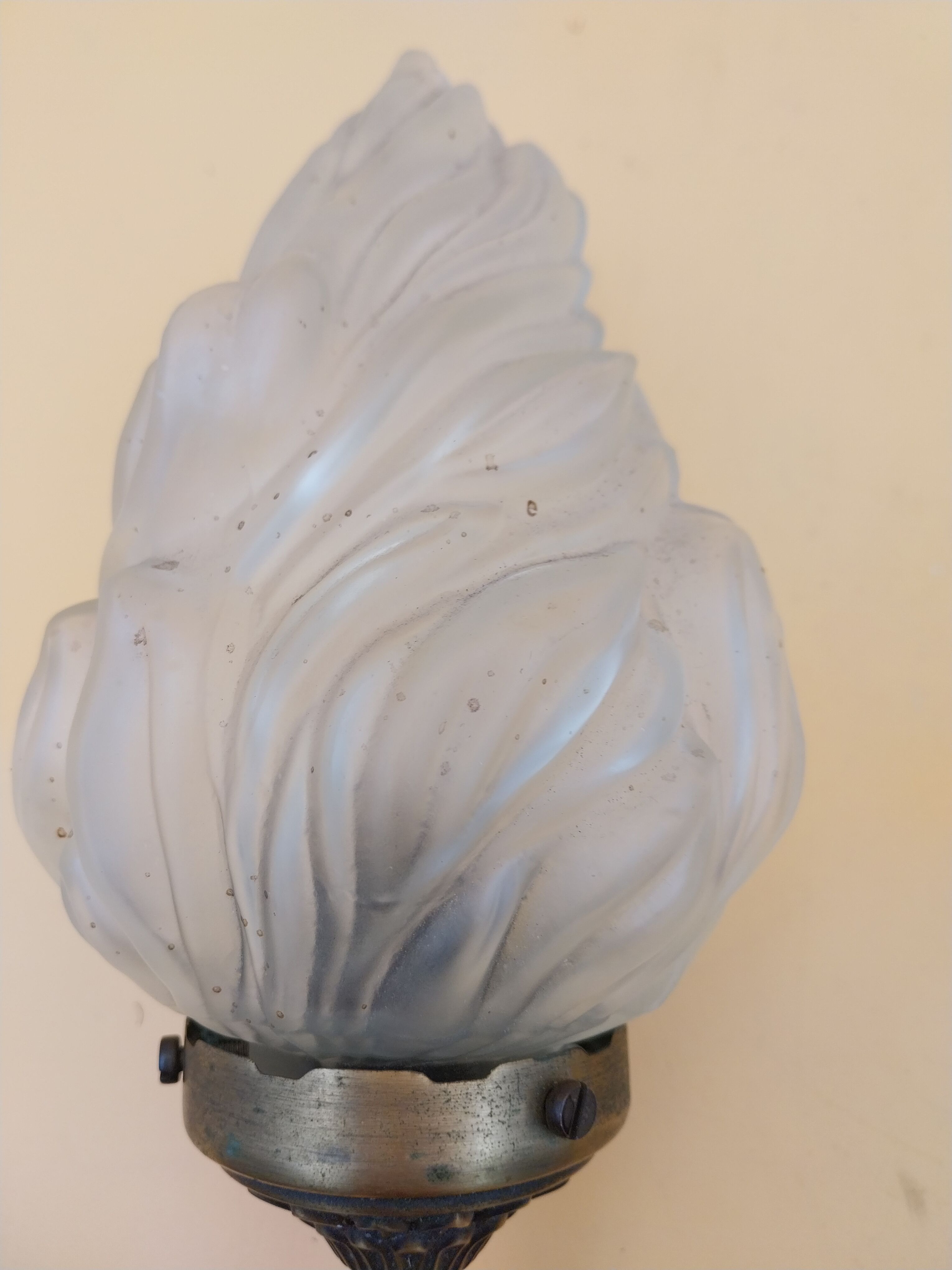 Pair of brass torch wall lights with globe flame.