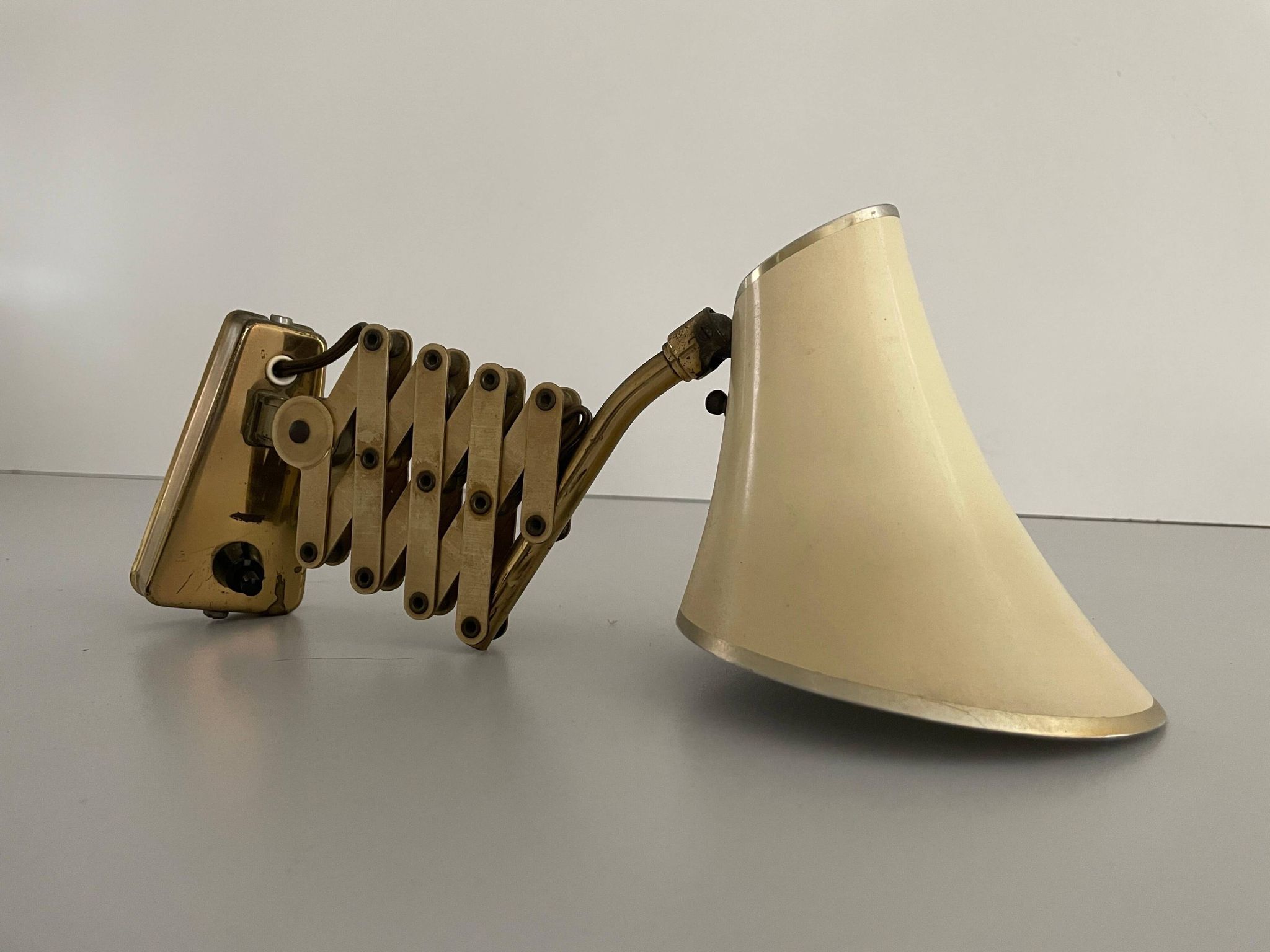 Cream metal and brass wall lamp with scissors design by Karl Lang for SIS Licht, 1950s, Germany.