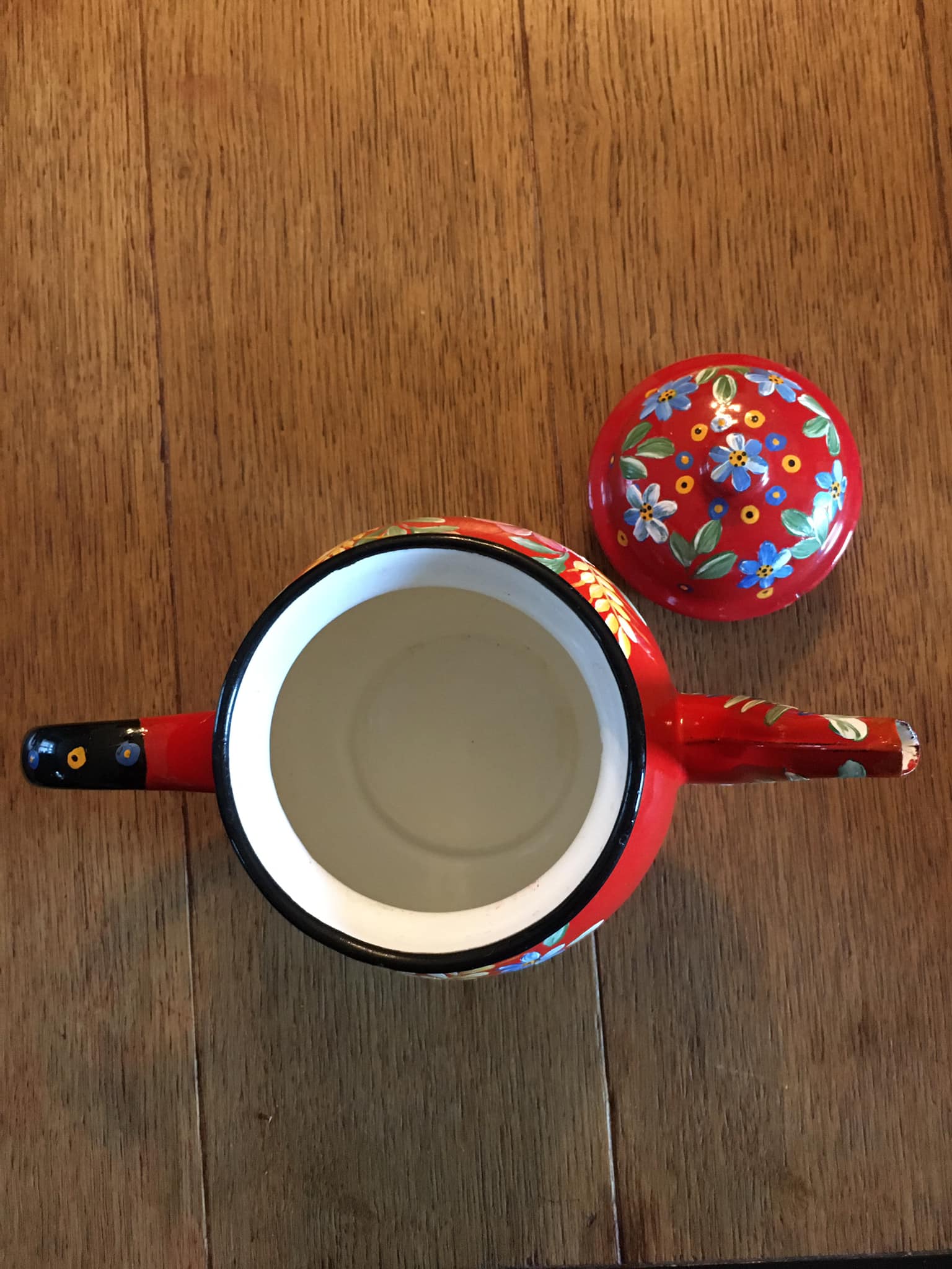 Red enamel teapot with hand-painted floral decoration