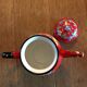 Red enamel teapot with hand-painted floral decoration