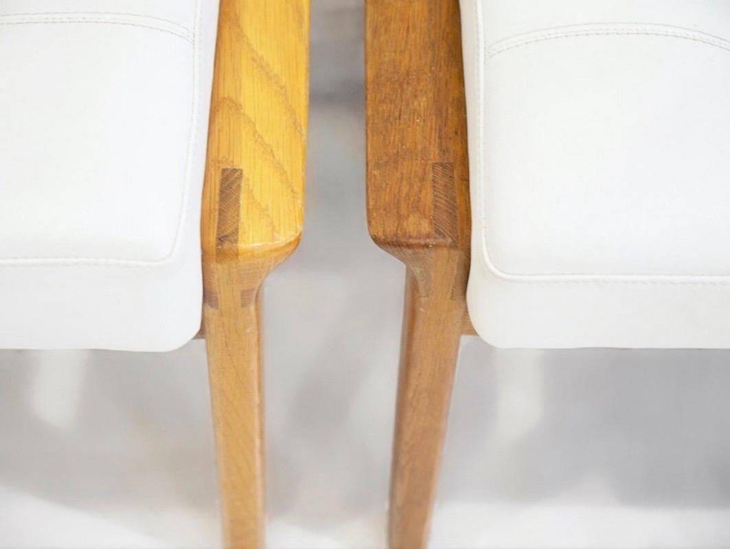 Paire d'ottomans tapissés en teck et cuir blanc
