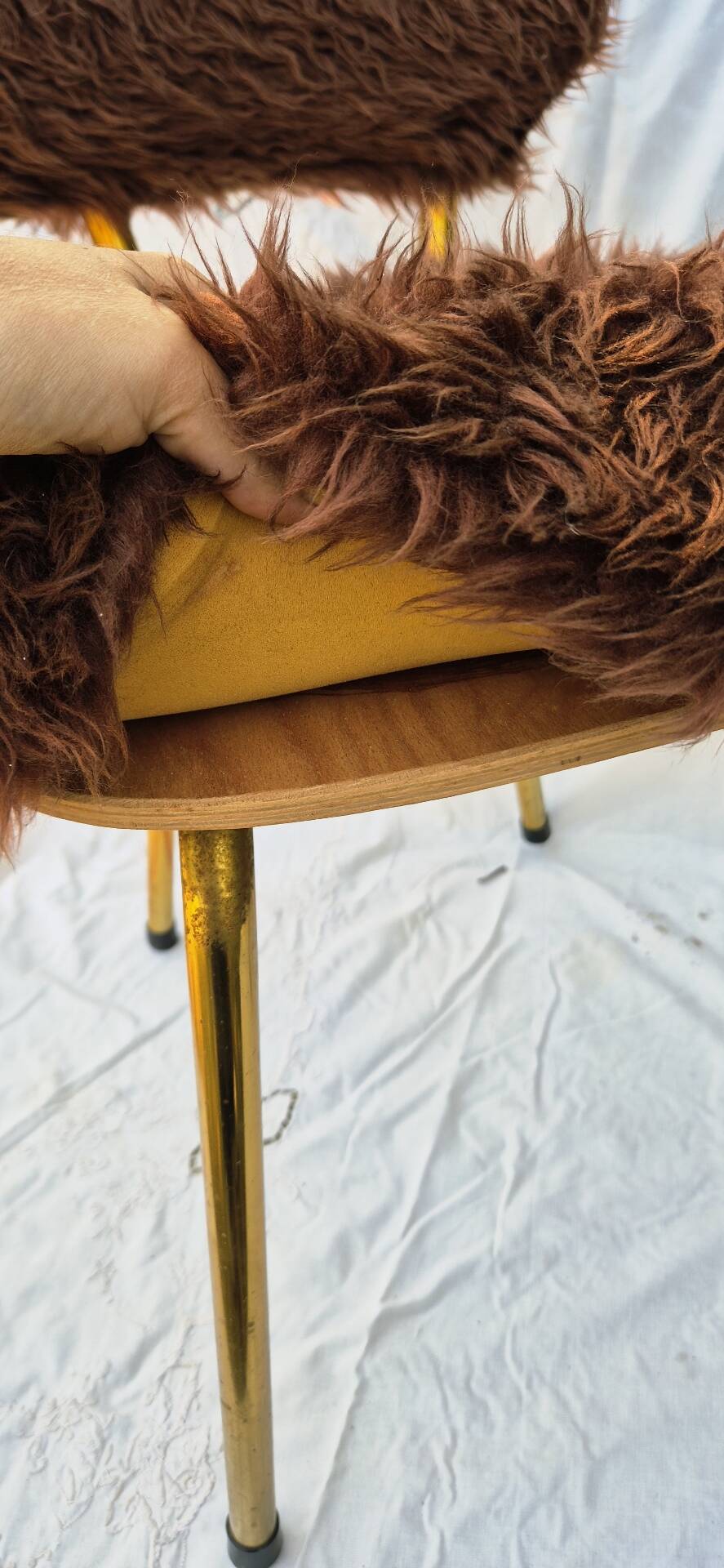 Vintage shaggy chair in faux fur with golden metal legs.