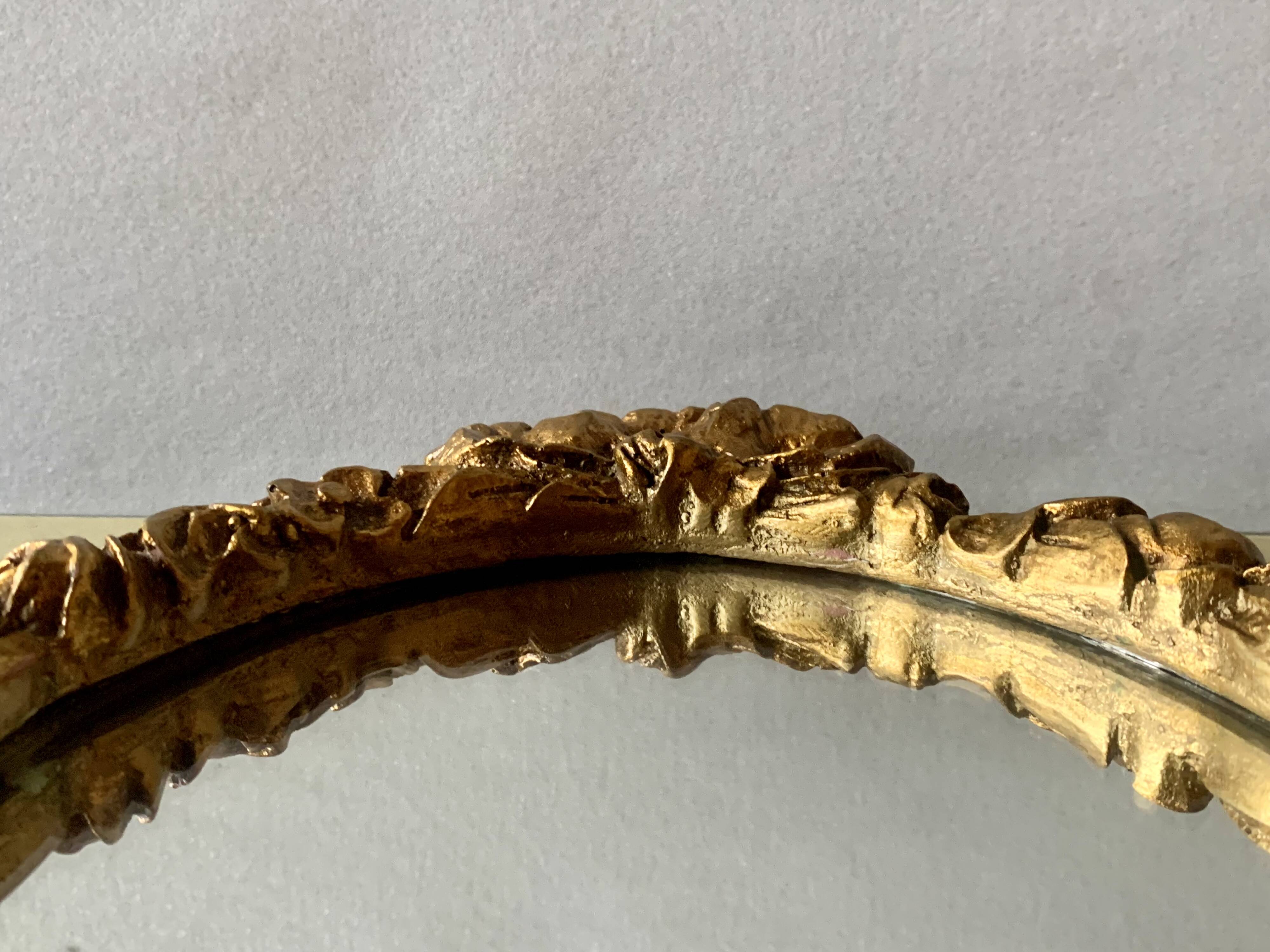 Small vintage oval wall mirror in varnished gold resin