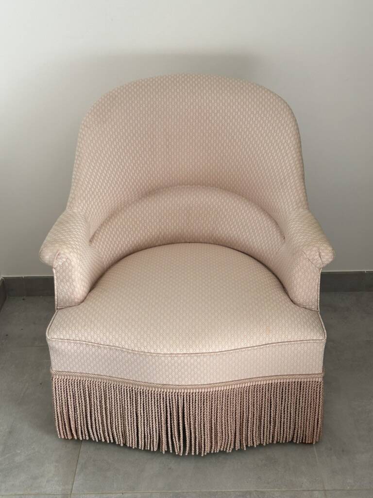 Pink armchair with patterns and fringes.