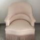 Pink armchair with patterns and fringes.