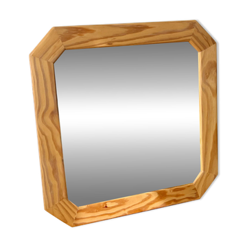 Octagonal mirror in light wood with grooves.