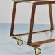 May include: A mid-century modern bar cart with a dark wood frame and two c