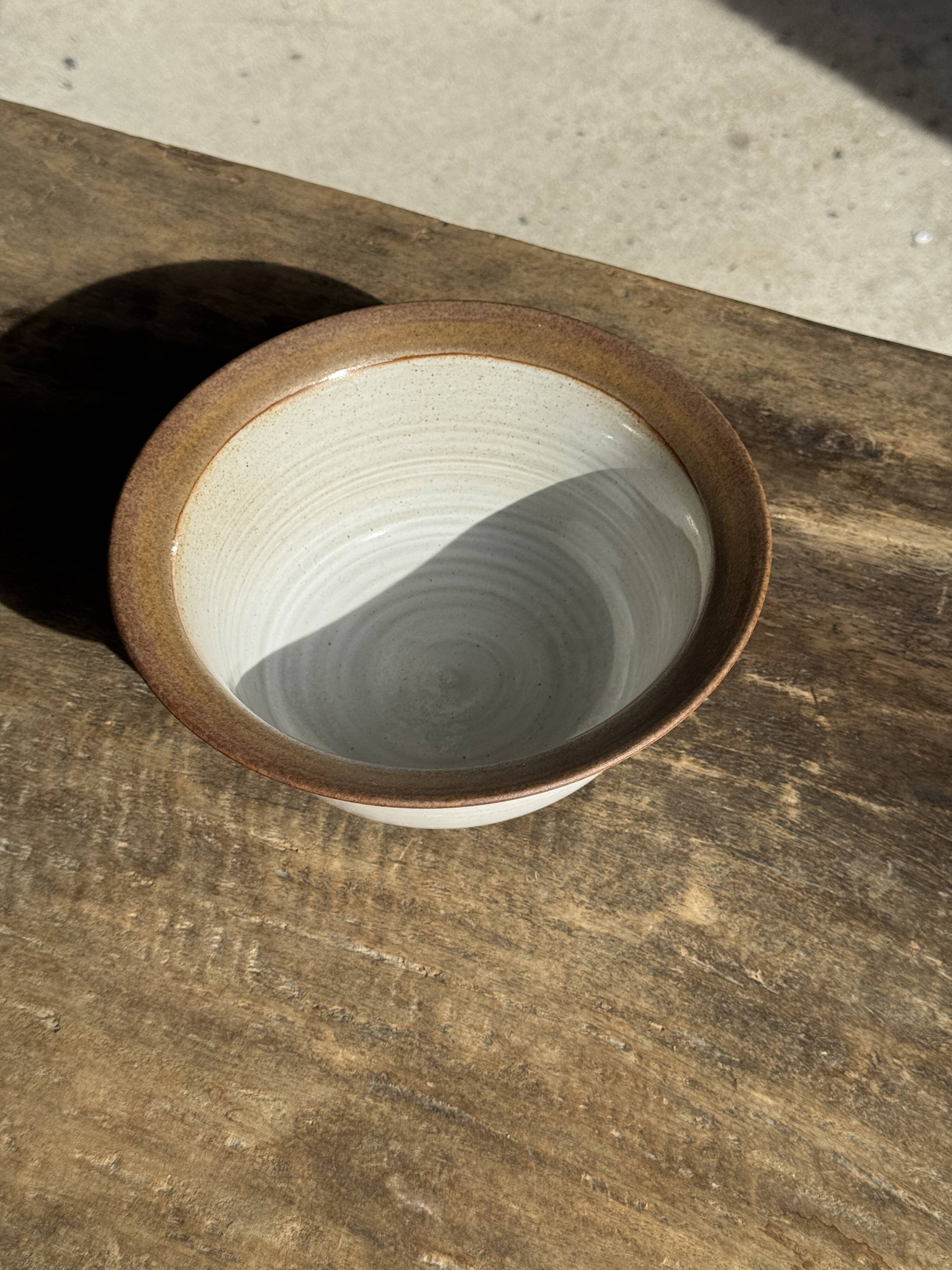 Small thick stoneware bowl with a stylised flower pattern in white on the outside, b