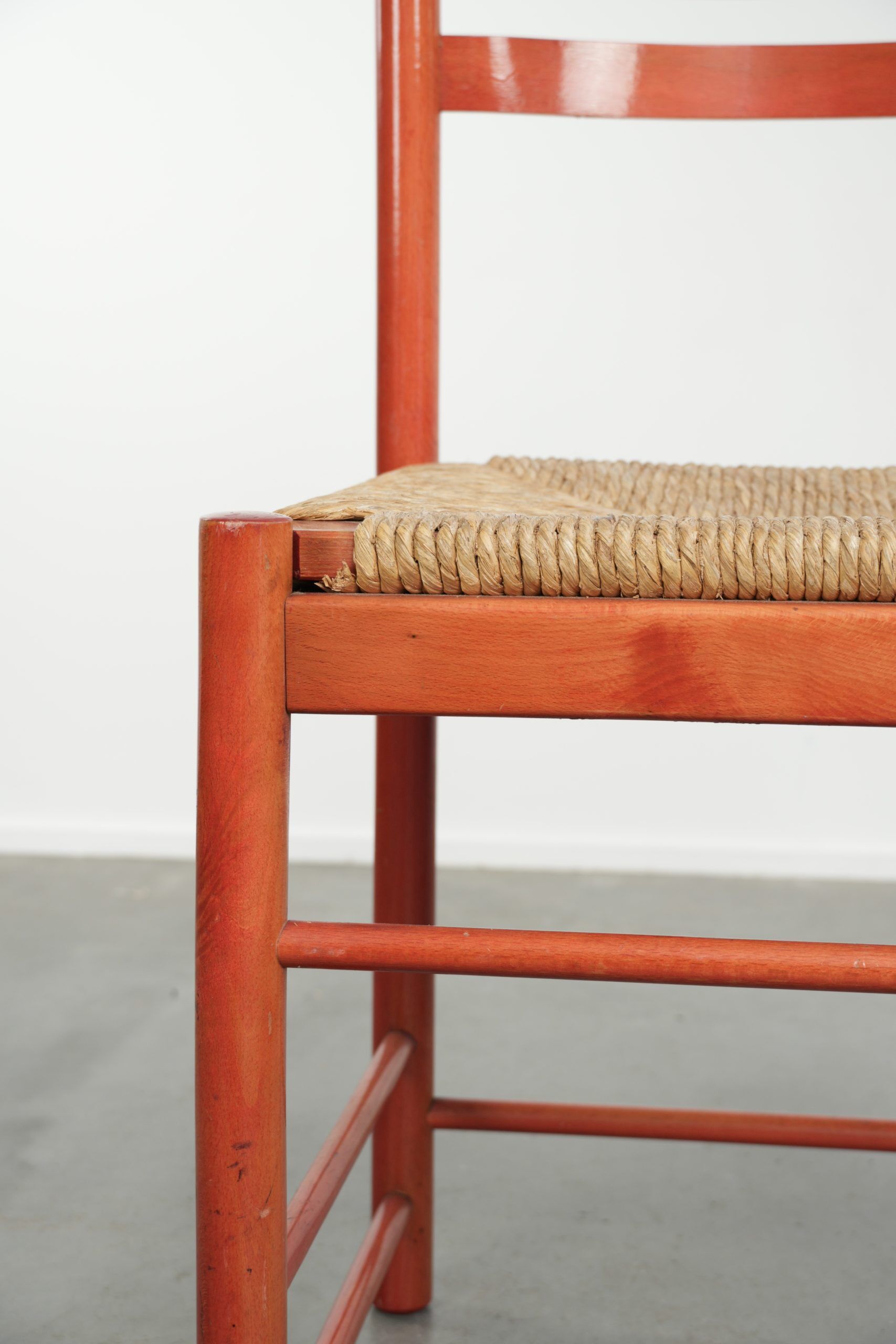 Nice red vintage wooden chair from the 1970s with a woven wicker seat