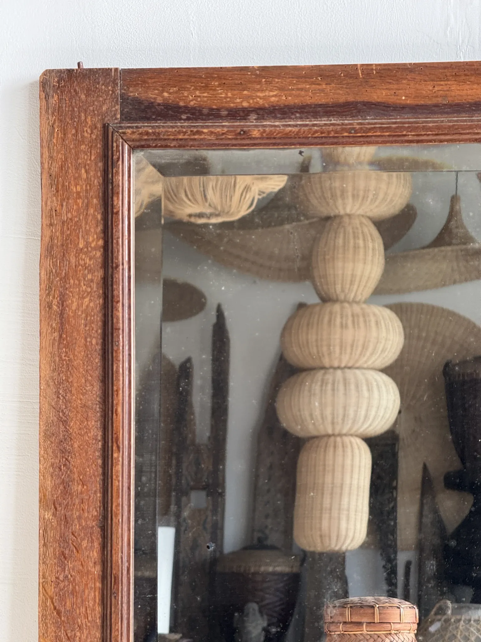 Antique mirror door (left) of a brown oak wardrobe with bevelled glass.