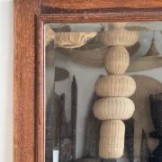 Antique mirror door (left) of a brown oak wardrobe with bevelled glass.