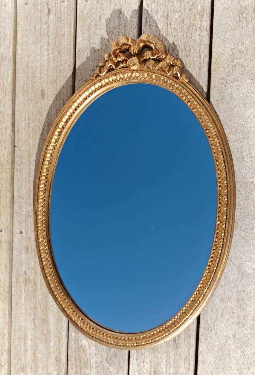 Authentic chic vintage oval mirror, in gilded wood, in baroque style.