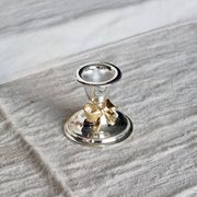 Small vintage silver-plated metal candlestick with a gold bow