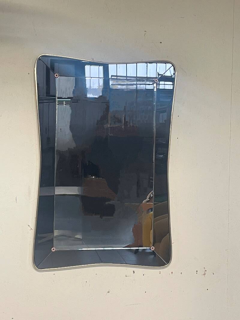1950s double-thickness wall mirror with brass profile and supports.