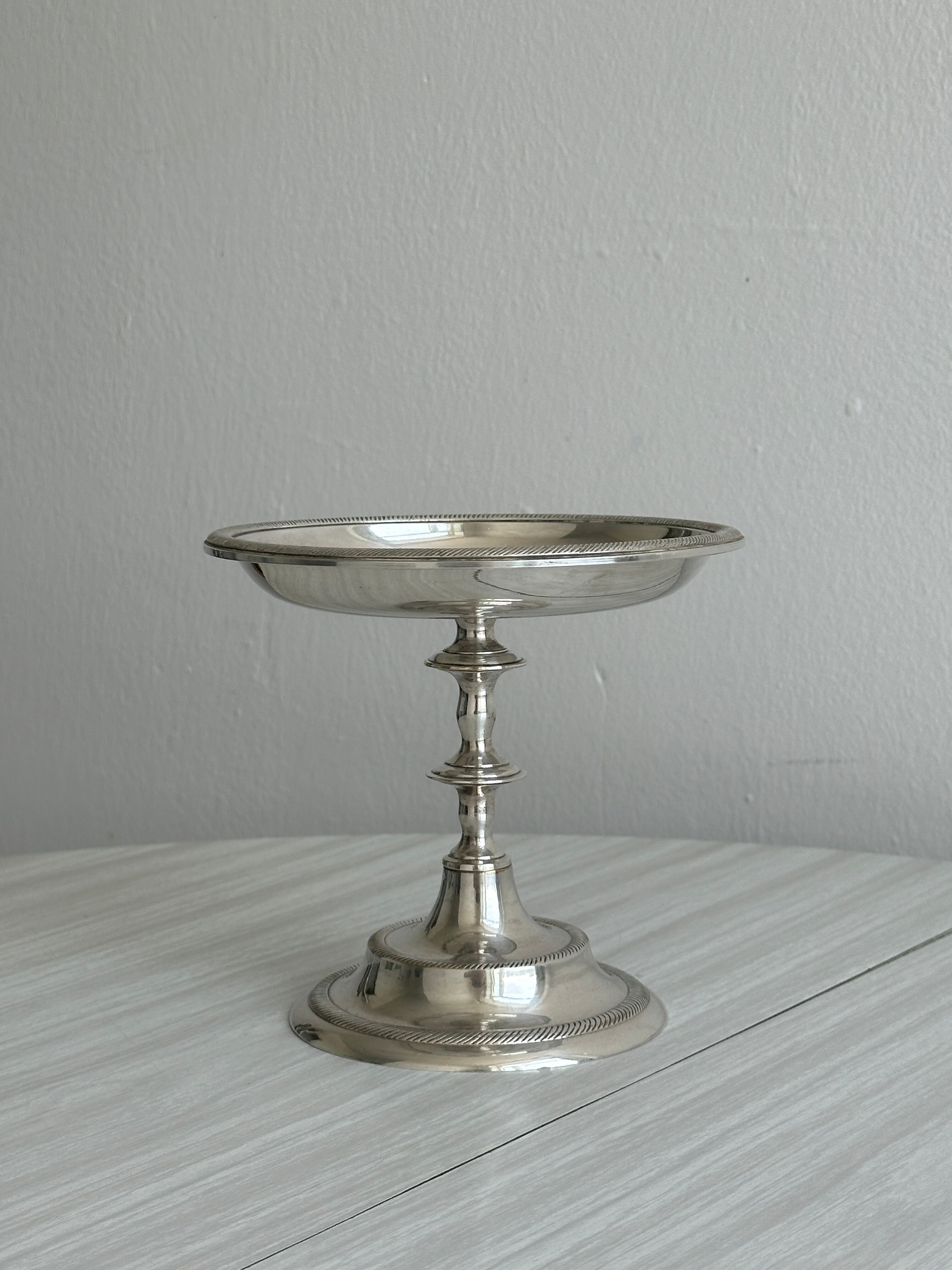 Silver-plated metal stand.