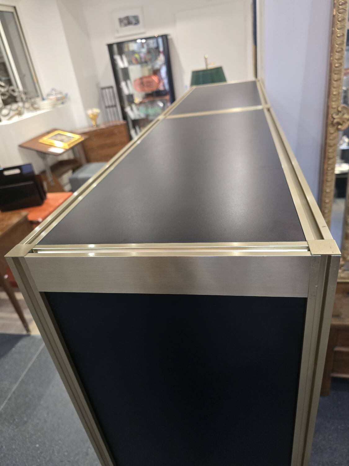 1970s design library with gold metal and lacquered wood.