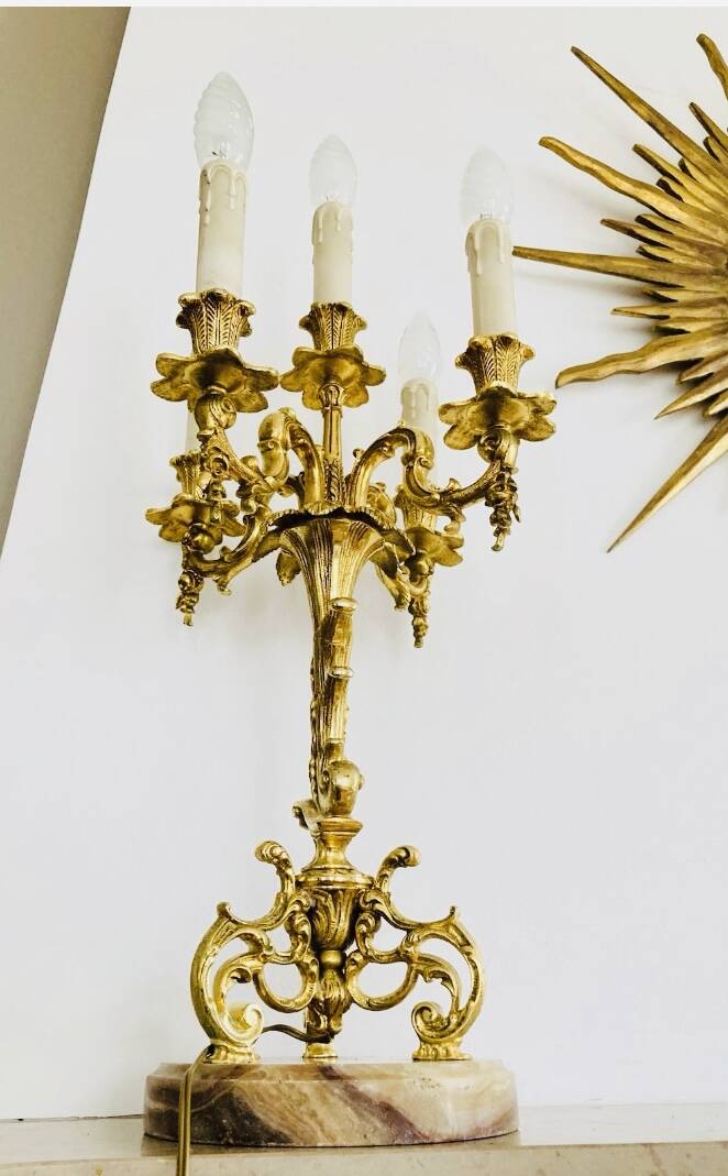 Massive gilded bronze chandeliers from the mid-20th century with marble bases.