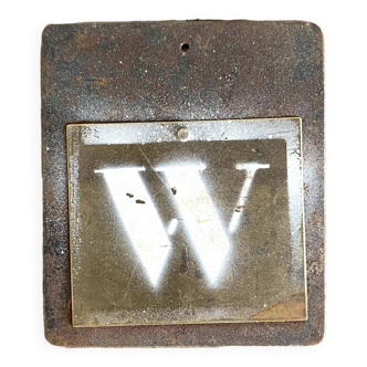 Metal letter W on plaque