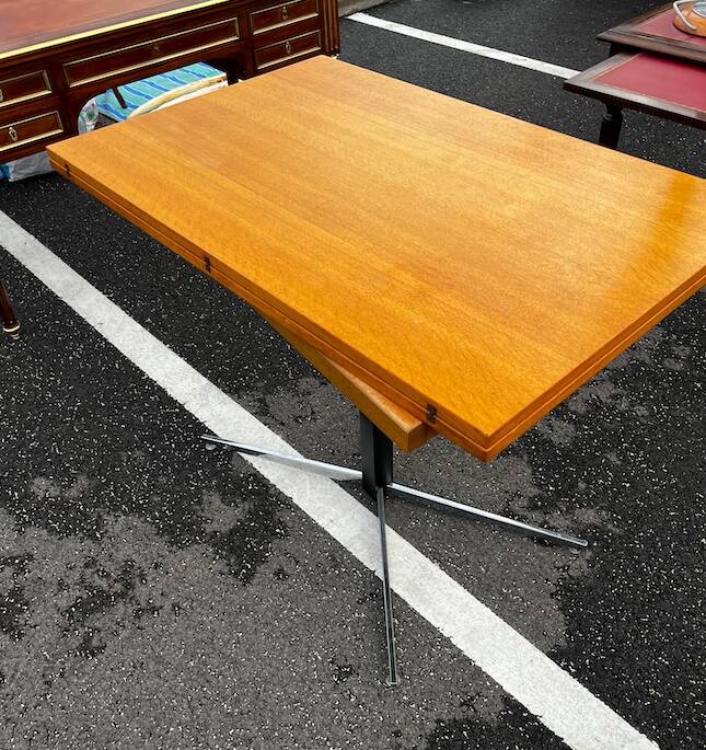 Table rises and lowers in light wood and metal.