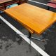 Table rises and lowers in light wood and metal.