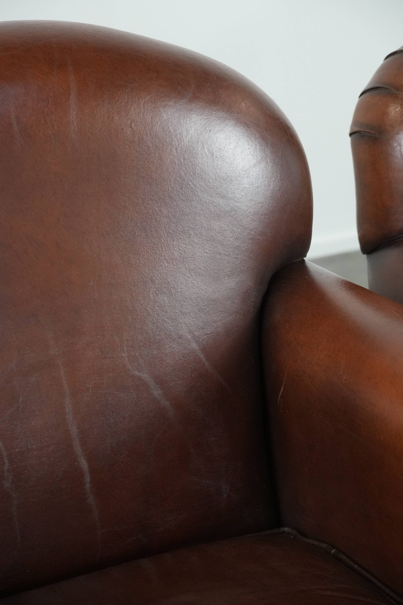 Ensemble de 2 fauteuils en peau de mouton au design art déco avec des couleurs chaudes.