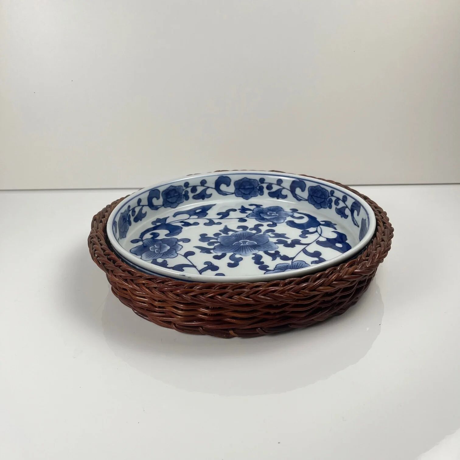 Set of 6 ceramic presentation plates in white and blue, floral pattern with woven wicker frame, 1970s/80s.