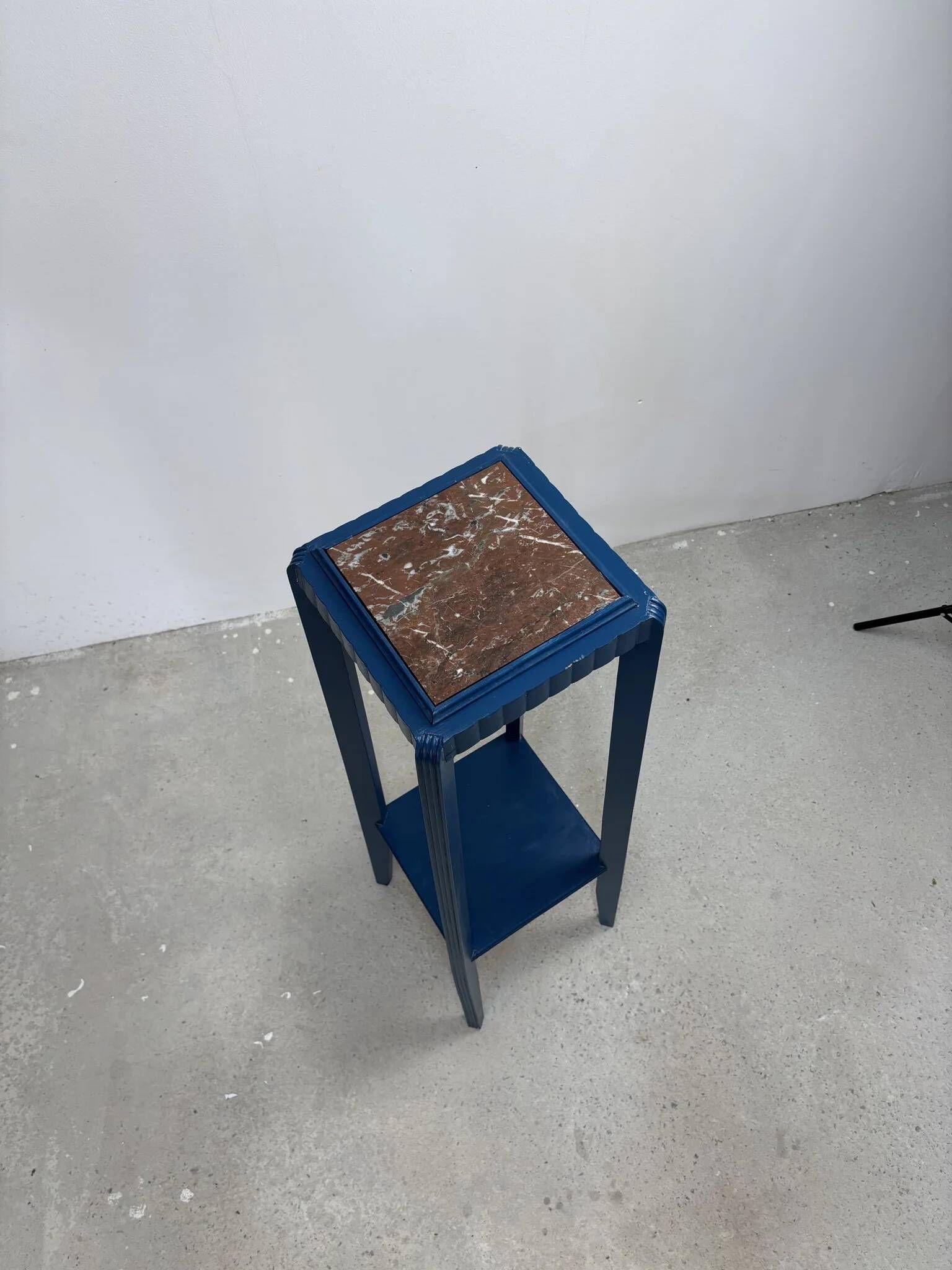 Blue side table with a veined stone top and a low shelf in the Art Deco style.