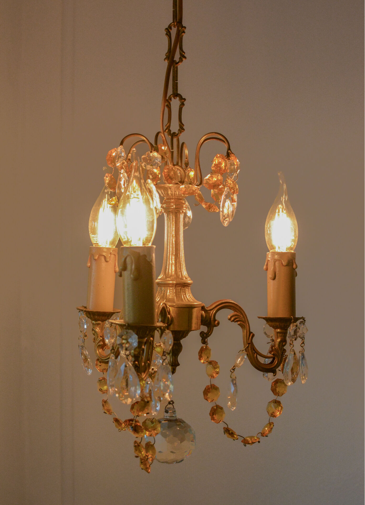Small vintage brass chandelier with amber crystal pendants.