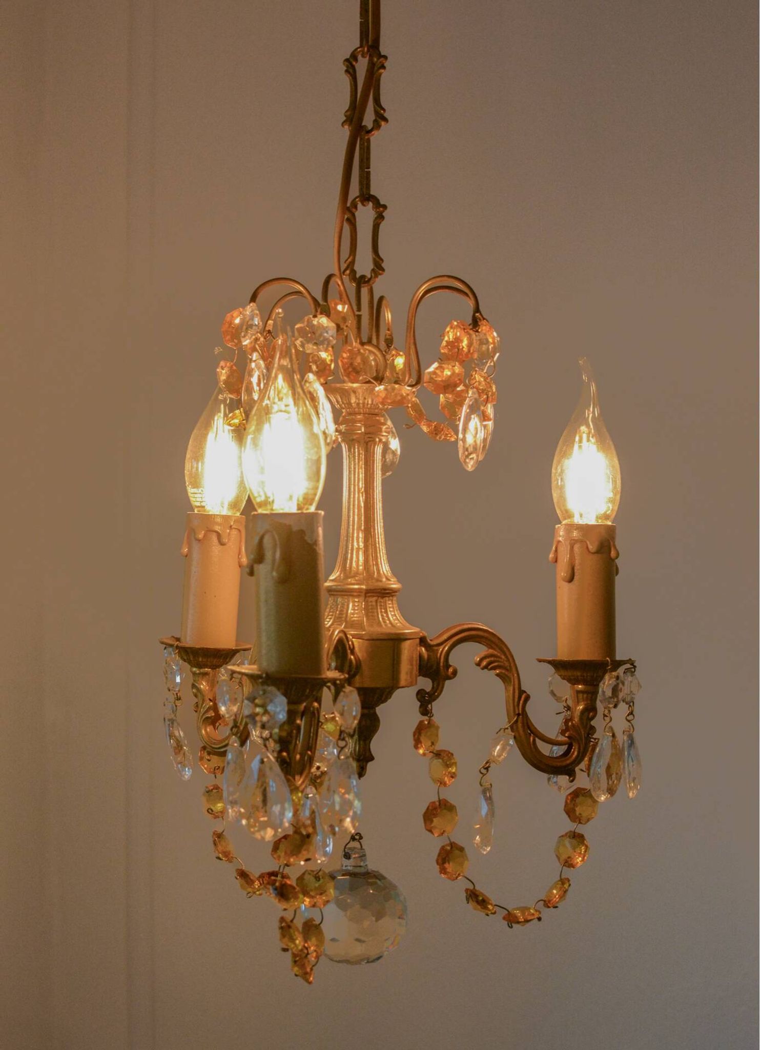 Small vintage brass chandelier with amber crystal pendants.