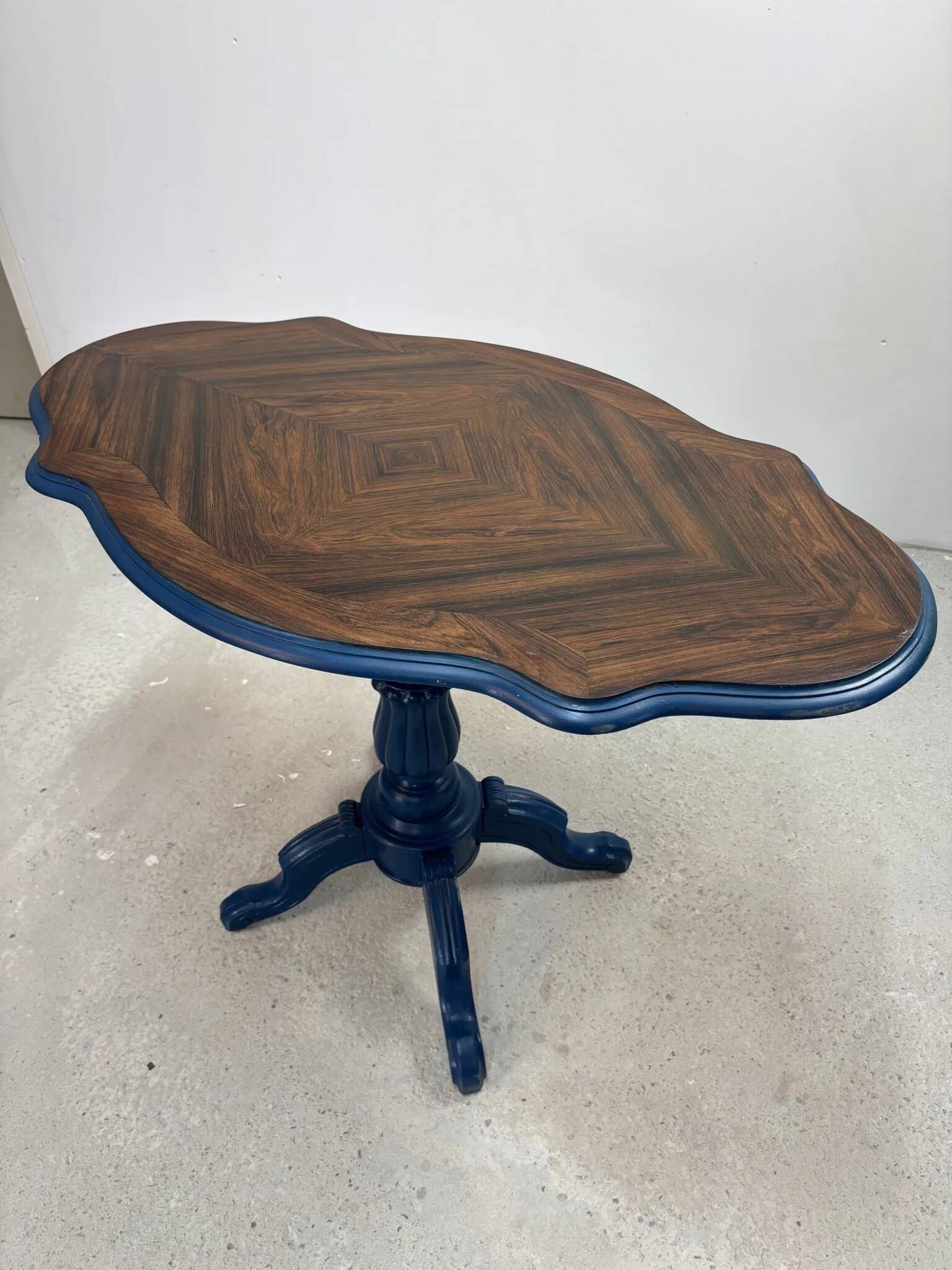 Wooden gueridon with a violin-shaped top in Rio rosewood, central base resting on four legs, reinterpreted in Baltic blue.